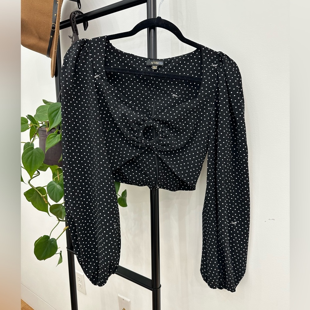 AFRM long sleeve crop top with circular chest embellishment.
